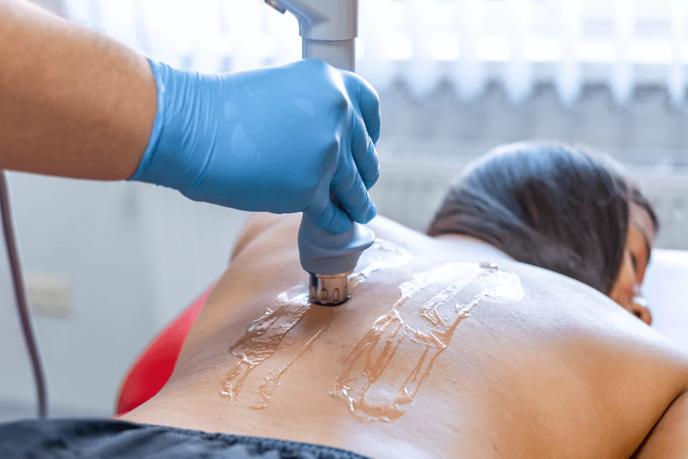 Die Physiotherapeutin in Nürnberg verwendet warme Steine und Kompresse um bei einer Kundin Wärmetherapie Nürnberg für Entspannung und Erleichterung zu sorgen